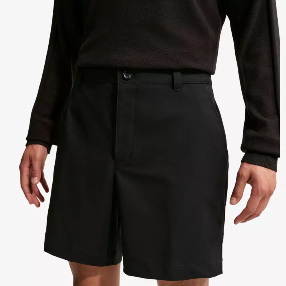 A person wearing a long-sleeve black shirt and black knee-length shorts stands with their arms relaxed at their sides, shown from chest to mid-thigh against a plain background—perfect attire for browsing the best golf travel bags.