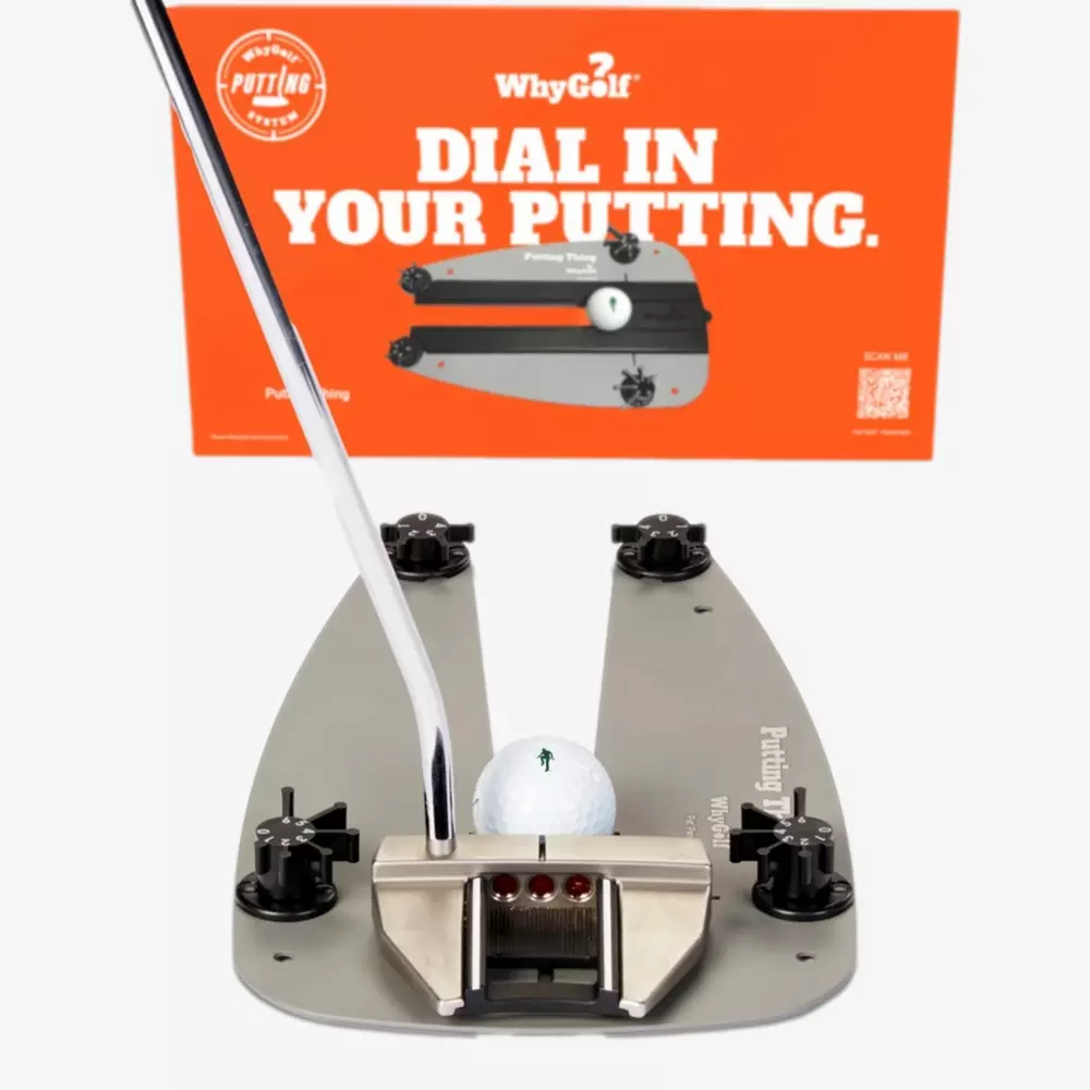 A golf putting training device holds a golf ball in place with a putter poised to strike. Behind it, an orange sign reads, WhyGolf: Dial In Your Putting—one of the best deals under $50 for golfers aiming to improve their game.