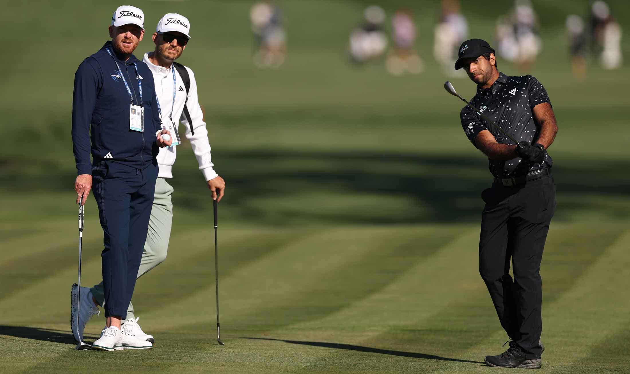 aron Rai of England plays his shot in front his coaches, Piers Ward and Andy Proudman, prior to THE PLAYERS Championship on the Stadium Course at TPC Sawgrass