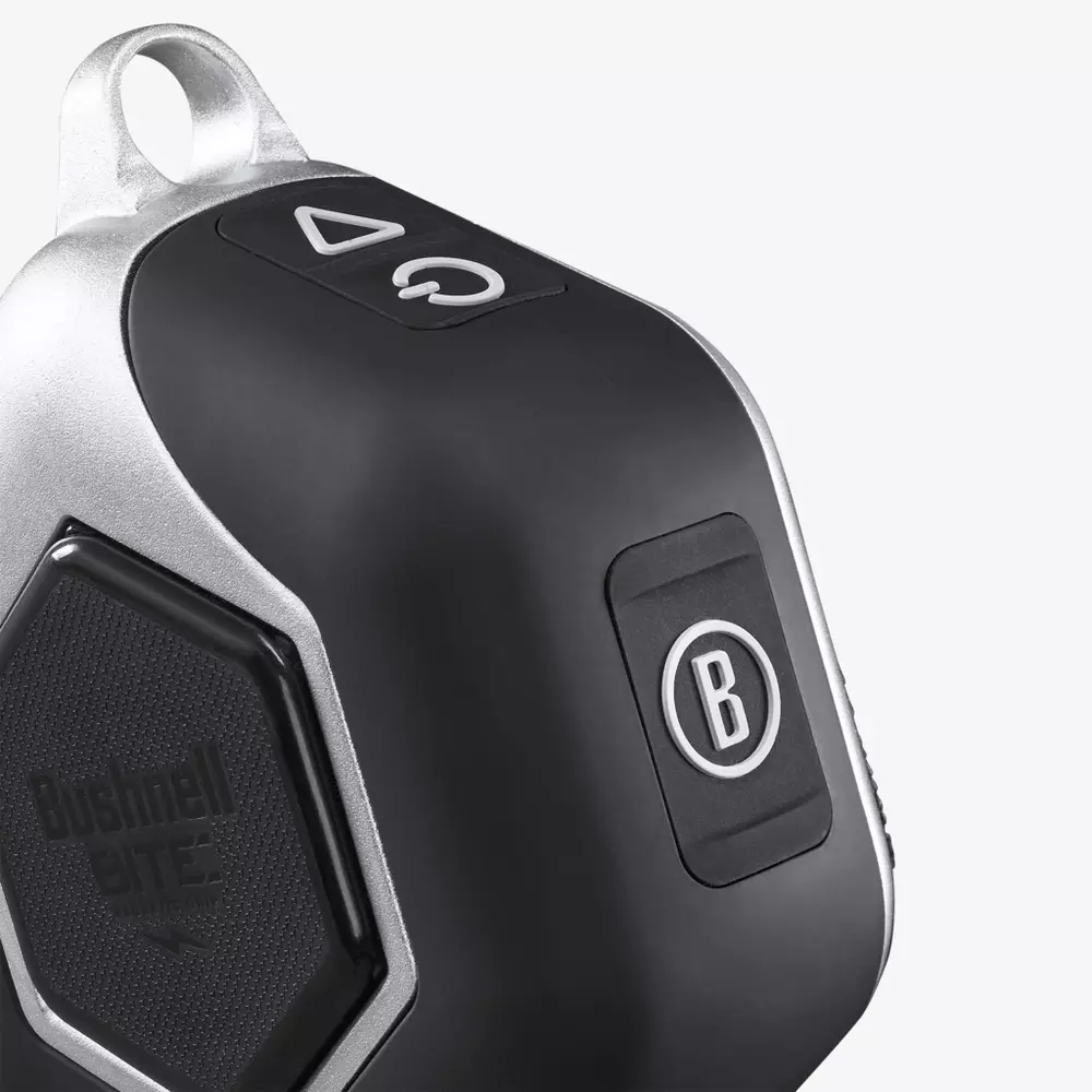 Close-up of a black and silver electronic device, featuring a B button, hexagonal textured Bushnell BITE area, and an arrow button on top&mdash;perfect for pairing with the best golf smartwatch. The corner includes a convenient loop for attachment.