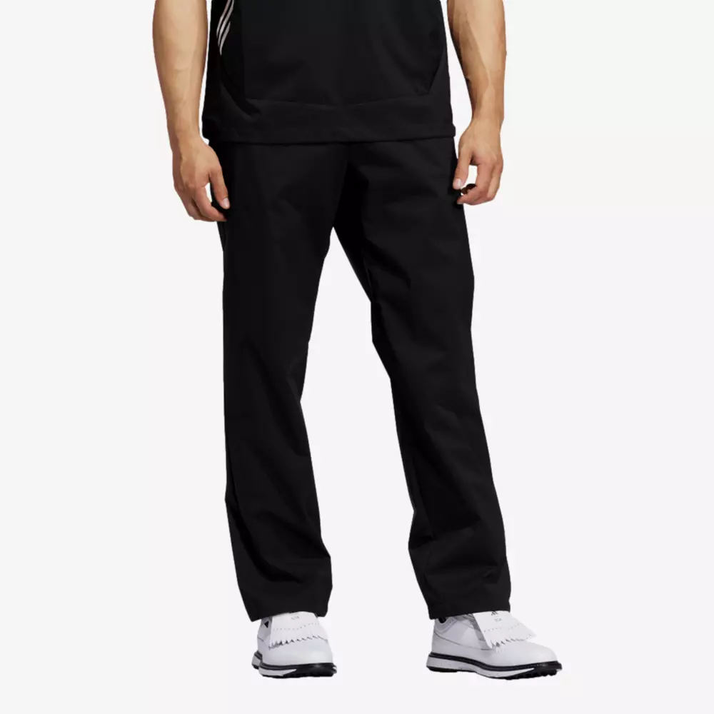 A person wearing black athletic pants, a black shirt, and white sneakers stands against a plain white background&mdash;perfect attire for browsing 6 Golf Deals Worth Buying Right Now. The image focuses on the lower half of the body.
