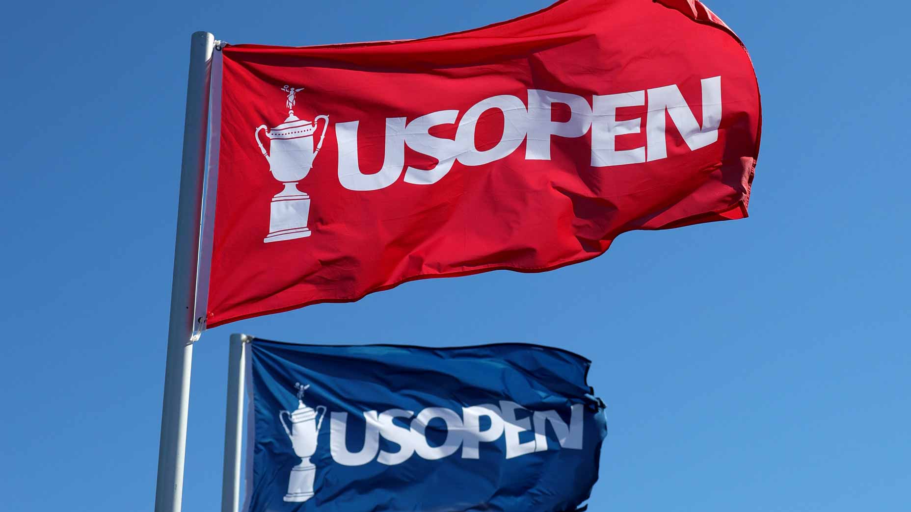 2026 U.S. Open flags flapping in wind at Shinnecock Hills Golf Club.