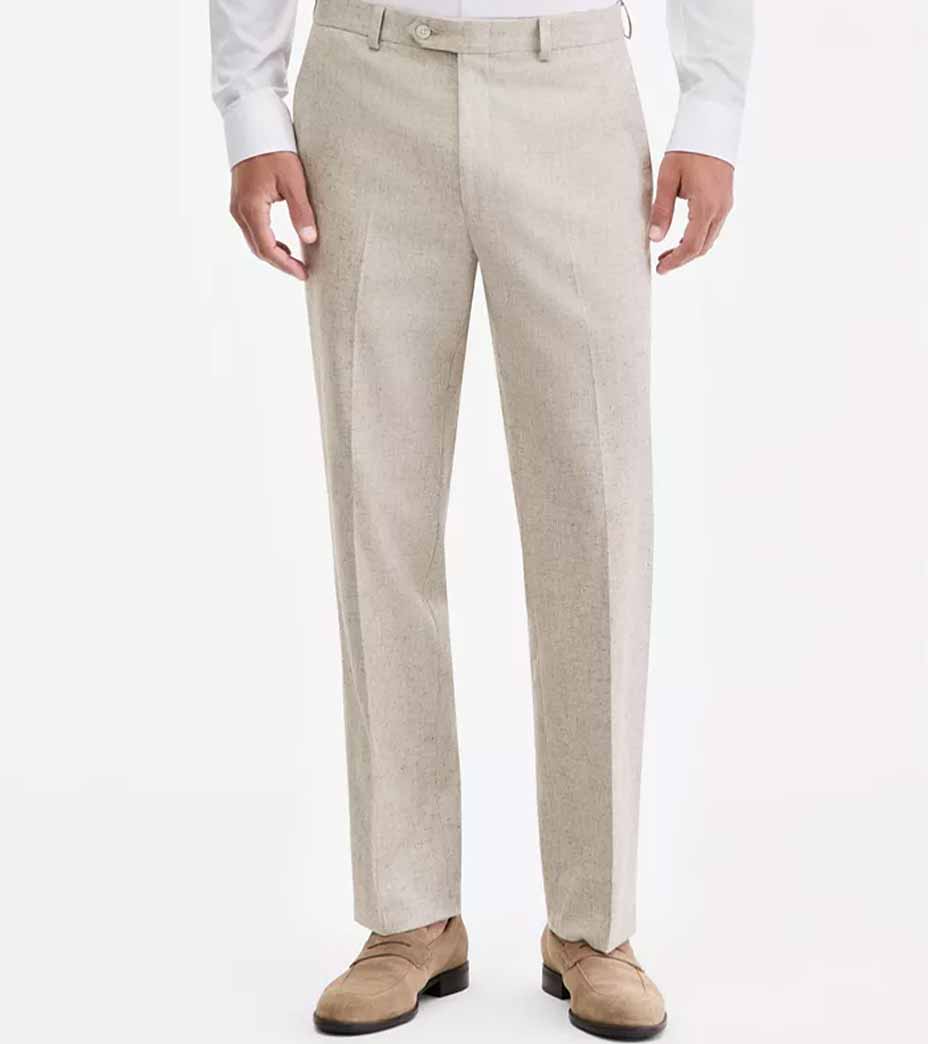 A person wearing light beige suit pants, a white dress shirt, and tan suede shoes, standing against a plain white background.