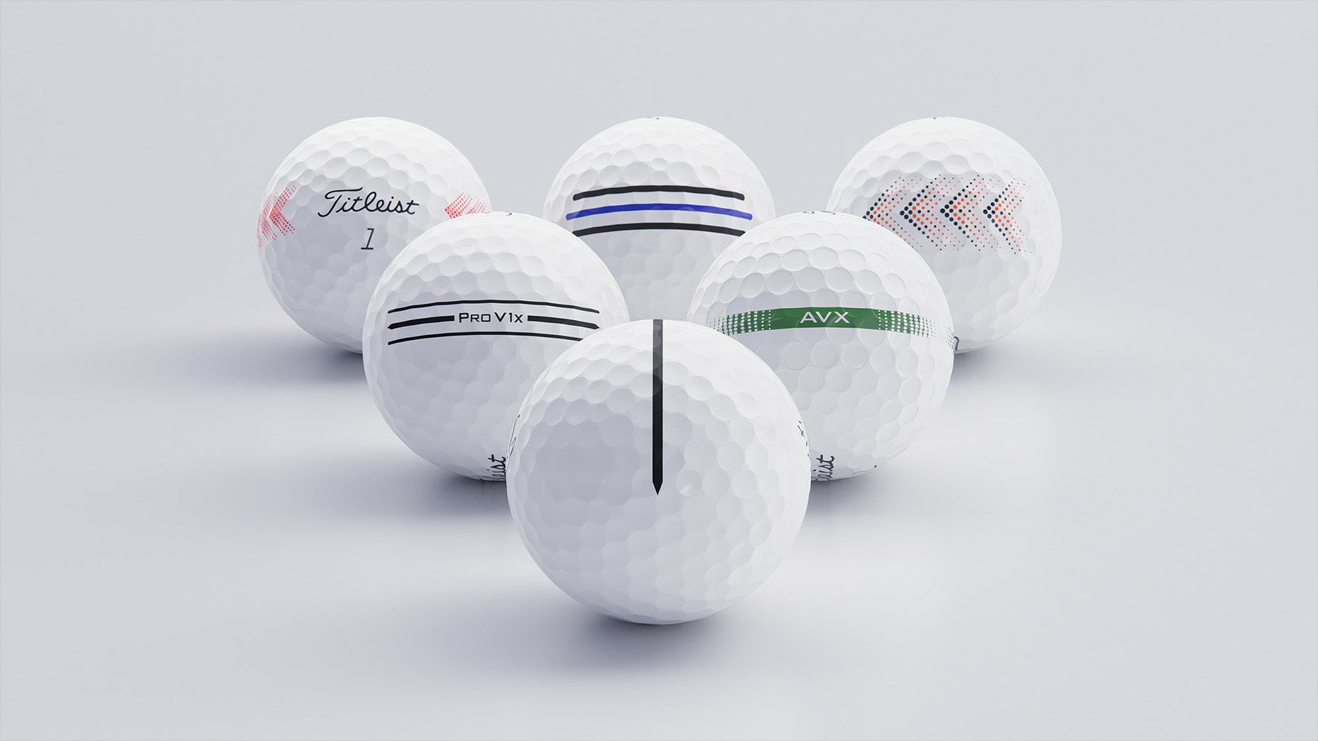 Six white golf balls are arranged in a loose cluster on a light surface. Each ball has unique markings, brand names, and colored stripes or patterns in black, red, blue, orange, and green.