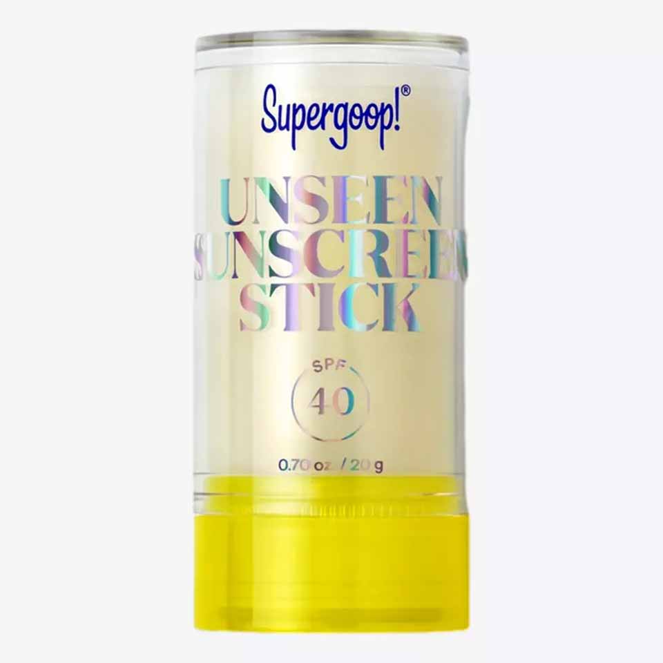 A clear stick of Supergoop! Unseen Sunscreen with SPF 40, featuring iridescent lettering on a transparent container and a bright yellow twist-up base—perfect as one of your thoughtful Father’s Day gifts.