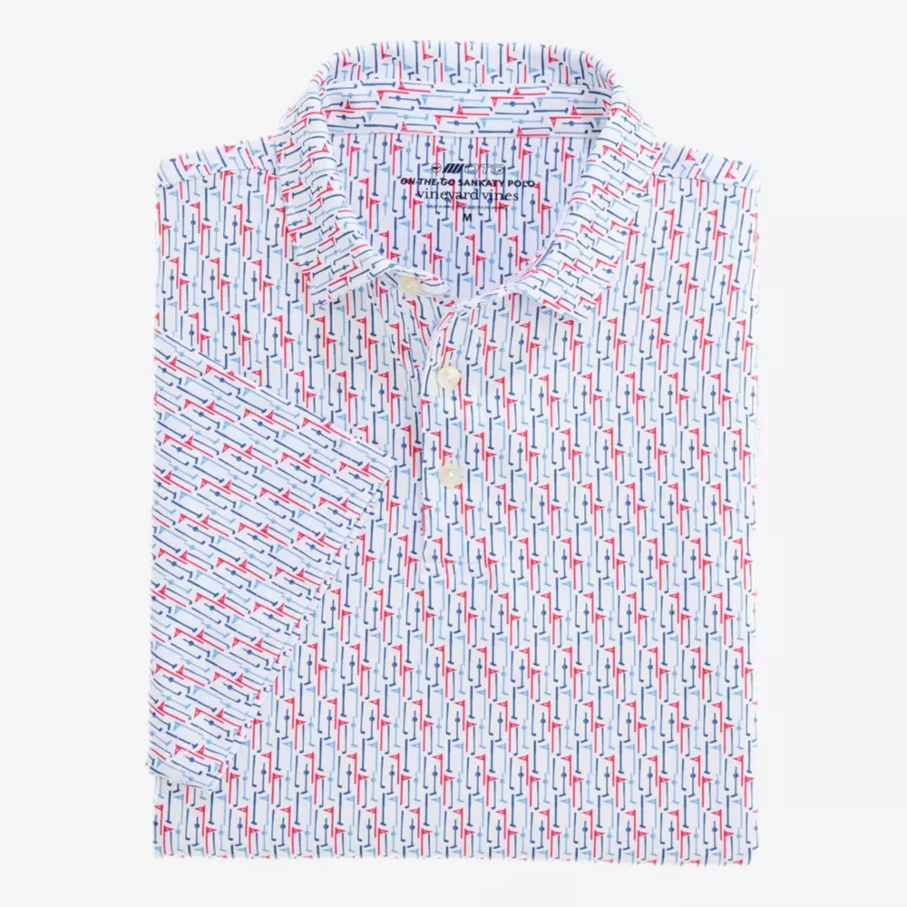 A neatly folded white collared shirt featuring a repeating pattern of blue, red, and navy geometric shapes, displayed on a plain light background.
